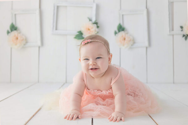 baby girl in pretty pink dress and a big smile